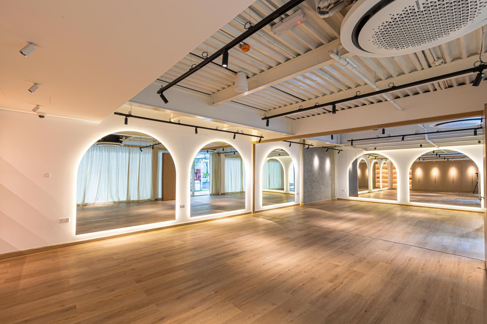 The Red Studio space in Dubai, lit arches, mirrors and wooden floor